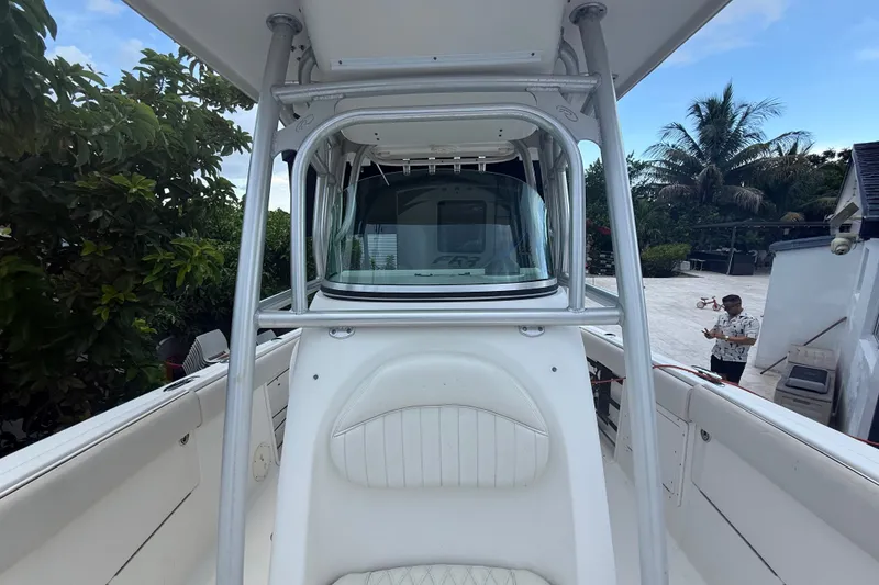 Slide: The Image of 2007 Robalo R260 Center Console boat with T-top, parked outdoors near tropical foliage. - 41