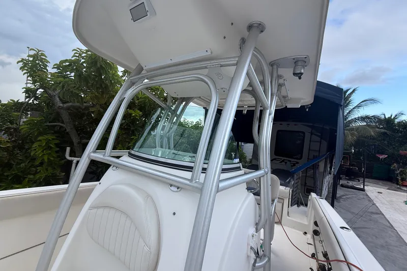 Slide: The Image of 2007 Robalo R260 Center Console boat with T-top and seating, surrounded by greenery. - 45