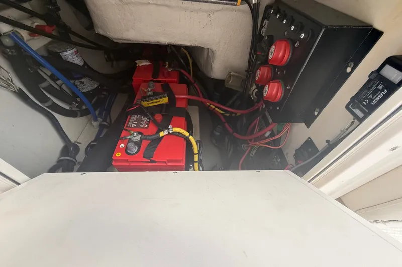 Slide: The Image of 2007 Robalo R260 Center Console boat battery compartment with wiring and control panel. - 55