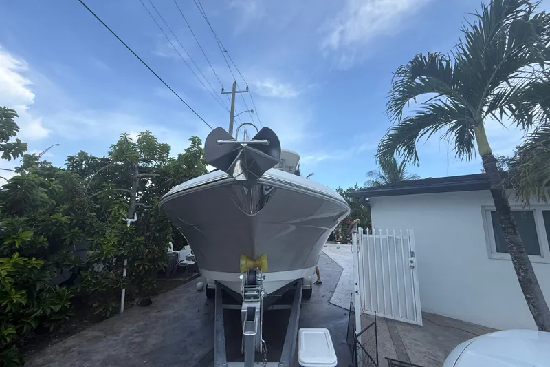 Slide: The Image of 2007 Robalo R260 Center Console boat on trailer, surrounded by tropical trees. - 1