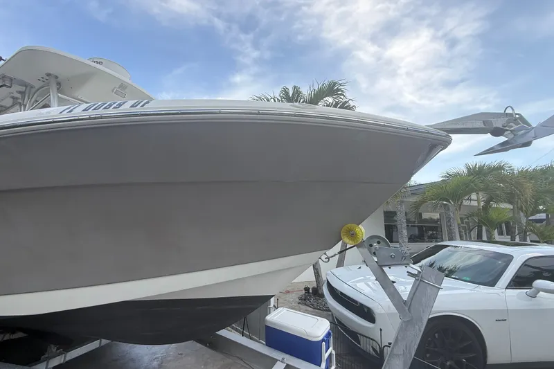 Slide: The Image of 2007 Robalo R260 Center Console boat on trailer beside a white car. - 29