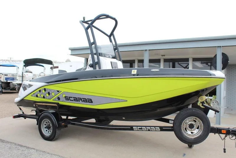 The Image of 2017 Scarab 195 boat with vibrant green and black design on a trailer. - 1