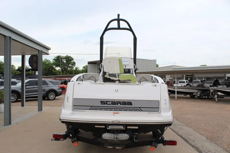 Slide: The Image of Rear view of a 2017 Scarab 195 boat parked outdoors, showcasing its sleek design. - 3