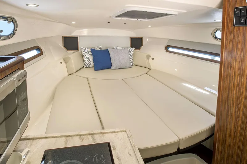 Slide: The Image of Manufacturer Provided Image: Interior cabin of 2021 Pursuit OS 325 Offshore boat with cozy seating and pillows. - 18