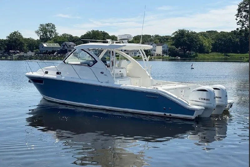 The Image of 2021 Pursuit OS 325 Offshore boat with twin Yamaha engines on a calm lake. - 0