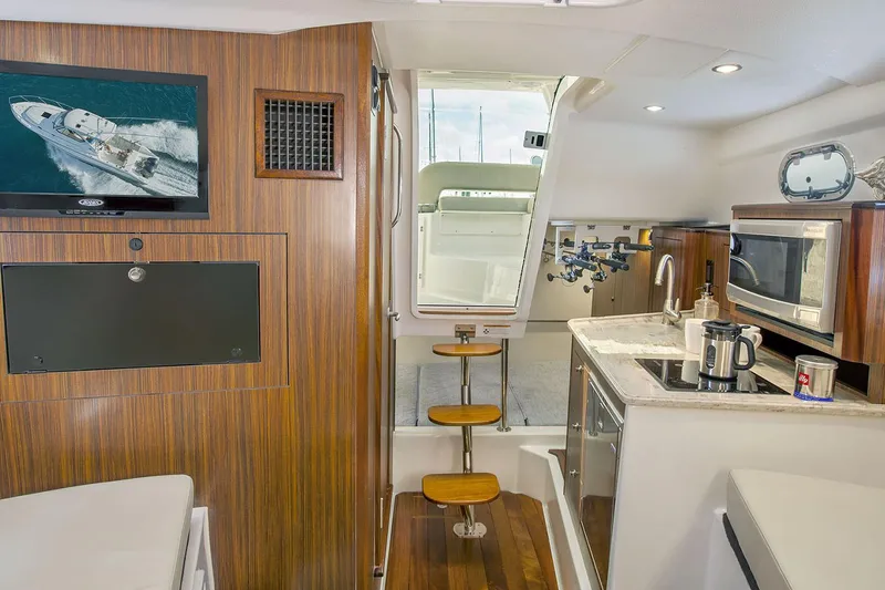 Slide: The Image of Manufacturer Provided Image: Interior of 2021 Pursuit OS 325 Offshore boat with kitchen and seating area. - 14