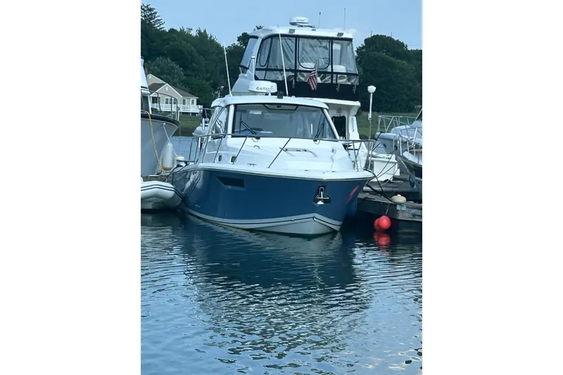 Slide: The Image of 2021 Pursuit OS 325 Offshore boat docked in a serene marina setting. - 3