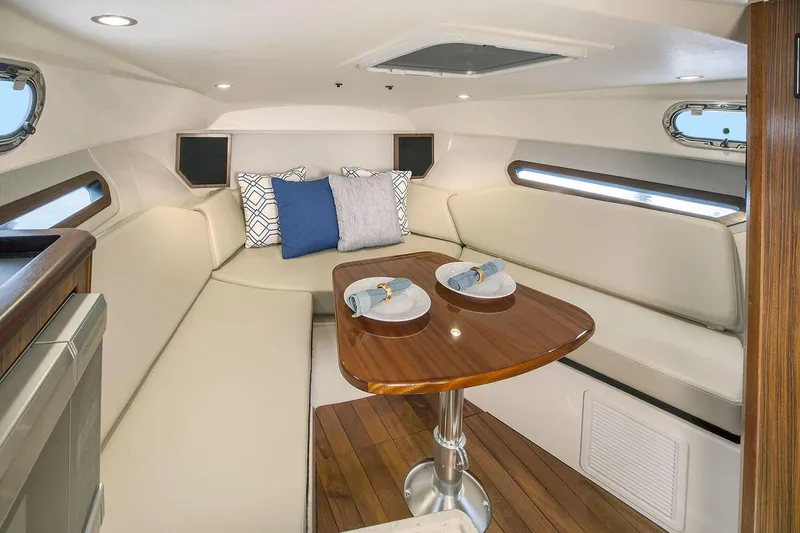 Slide: The Image of Manufacturer Provided Image: 2021 Pursuit OS 325 Offshore cabin with dining table and cushioned seating. - 19