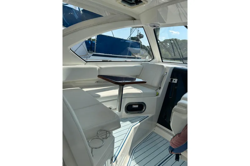 Slide: The Image of Interior of 2021 Pursuit OS 325 Offshore boat with white seating and wooden table. - 11