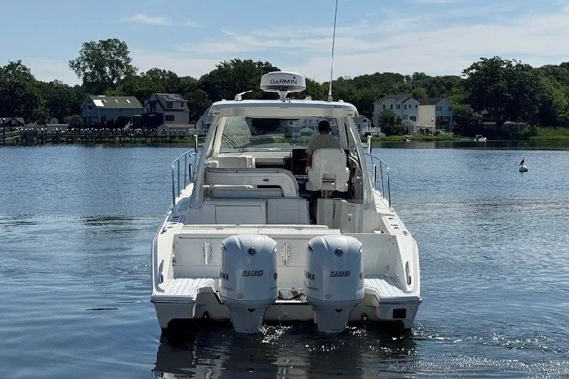 Slide: The Image of 2021 Pursuit OS 325 Offshore boat with dual Yamaha engines on a calm lake. - 11