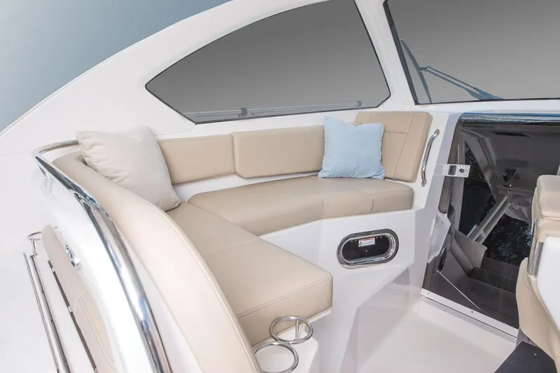 Slide: The Image of Manufacturer Provided Image: Interior seating area of 2021 Pursuit OS 325 Offshore boat with beige cushions. - 8