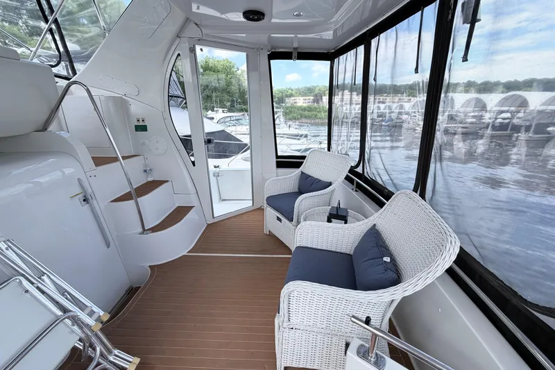 Slide: The Image of 2003 Carver 396 Motor Yacht interior with wicker chairs and panoramic windows. - 4
