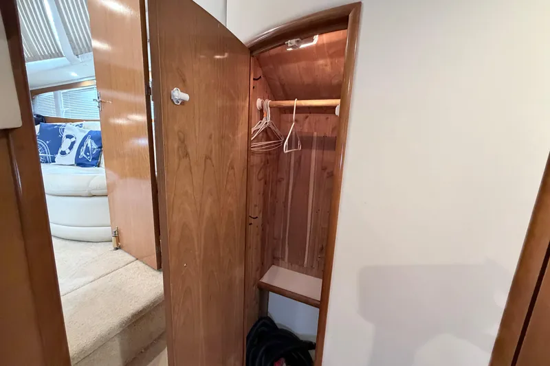 Slide: The Image of Interior view of a 2003 Carver 396 Motor Yacht closet with wooden finish and hangers. - 37