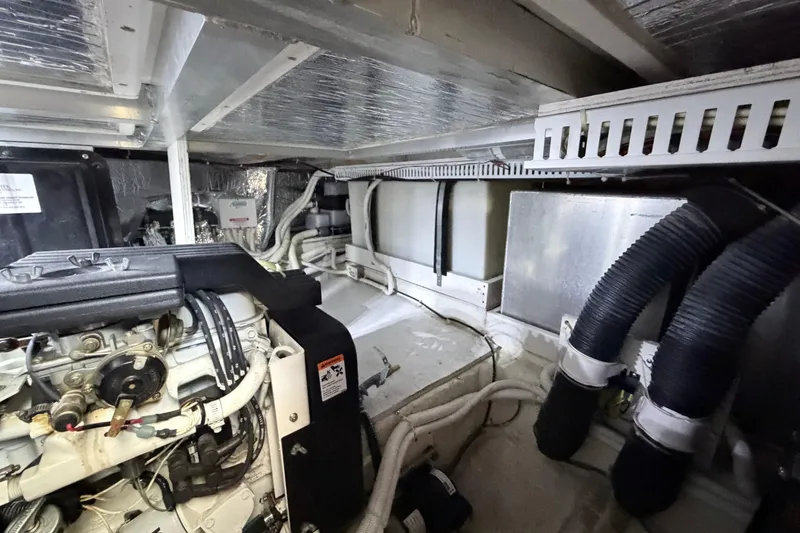 Slide: The Image of Engine room of a 2003 Carver 396 Motor Yacht, showcasing mechanical components and wiring. - 48