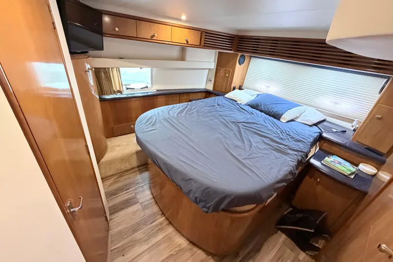 Slide: The Image of Luxurious bedroom interior of 2003 Carver 396 Motor Yacht with cozy bed and wooden cabinetry. - 31