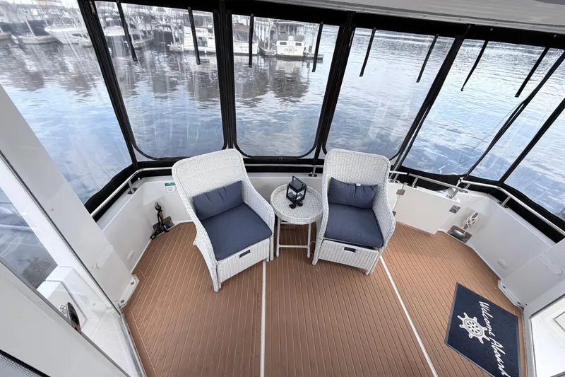 Slide: The Image of 2003 Carver 396 Motor Yacht interior with wicker chairs and marina view. - 12