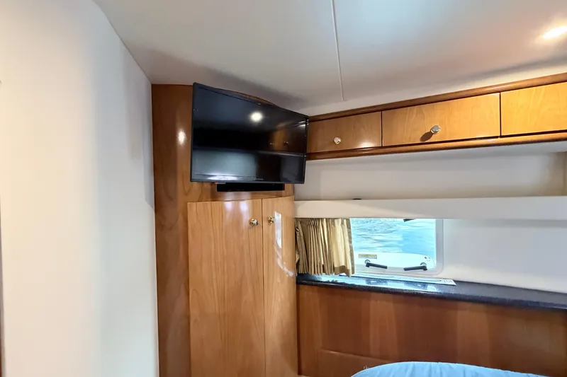 Slide: The Image of Interior of 2003 Carver 396 Motor Yacht with TV, wooden cabinets, and window view. - 33