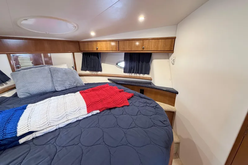 Slide: The Image of Luxurious 2003 Carver 396 Motor Yacht bedroom with cozy bedding and elegant wood accents. - 25