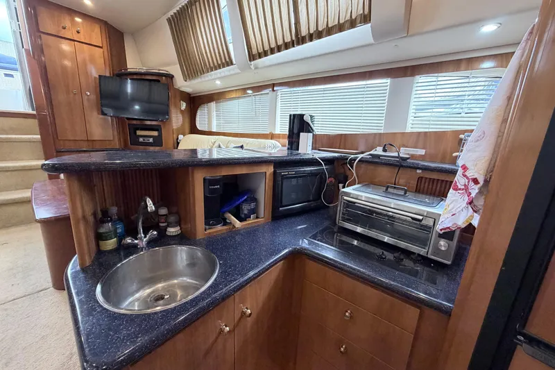 Slide: The Image of Luxurious 2003 Carver 396 Motor Yacht kitchen with modern appliances and elegant wood cabinetry. - 20