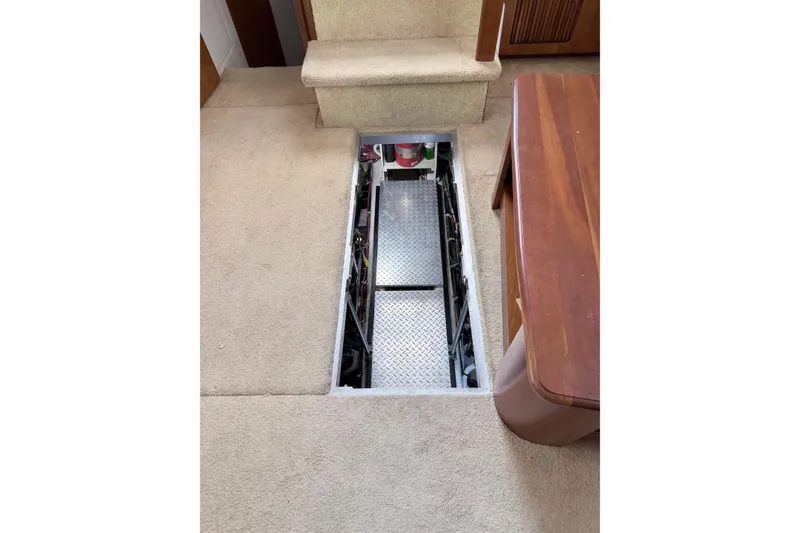 Slide: The Image of Engine compartment access on 2003 Carver 396 Motor Yacht, featuring carpeted interior and wooden furniture. - 41