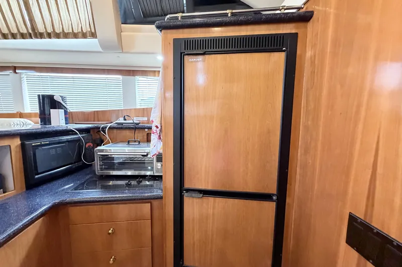 Slide: The Image of Interior of 2003 Carver 396 Motor Yacht kitchen with wooden cabinetry and appliances. - 21