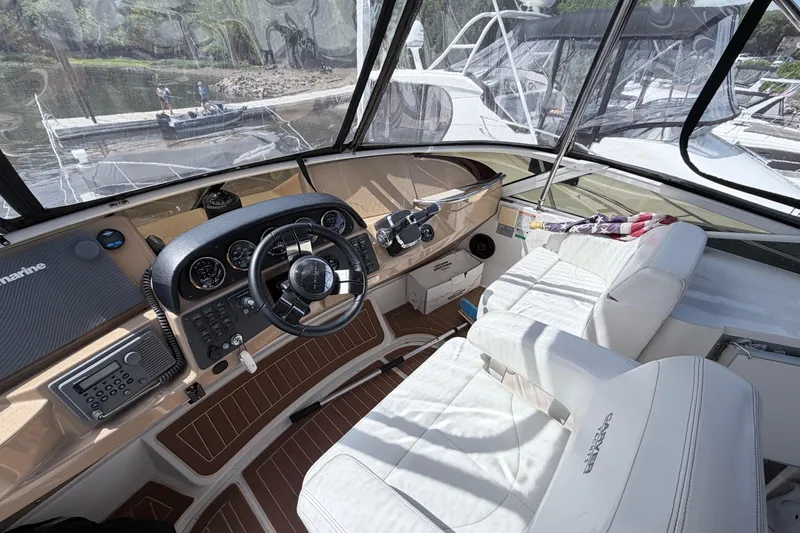 Slide: The Image of Interior view of 2003 Carver 396 Motor Yacht helm with white seating and control panel. - 8