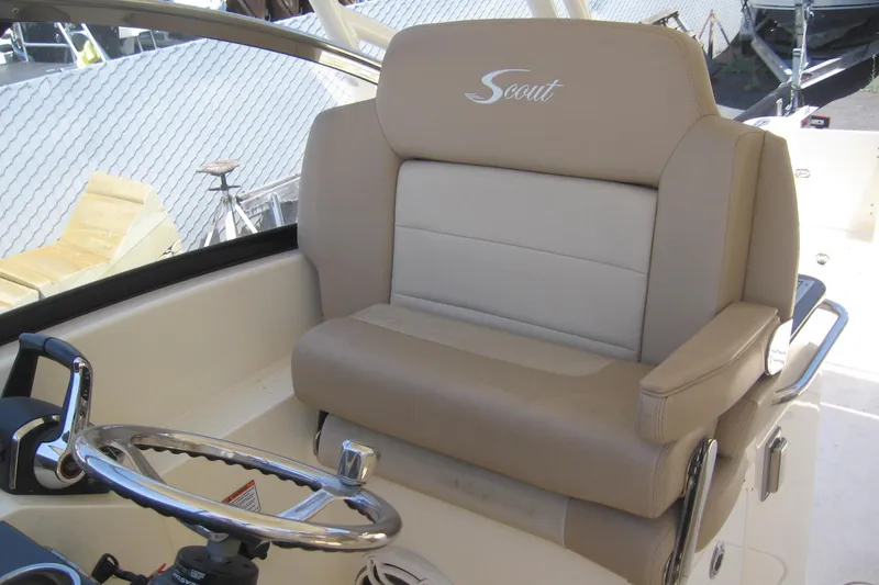 Slide: The Image of 2024 Scout 255 Dorado boat helm with beige leather seating and steering wheel. - 6