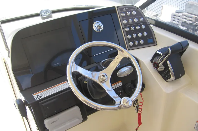 Slide: The Image of 2024 Scout 255 Dorado boat dashboard with steering wheel and control panel. - 3