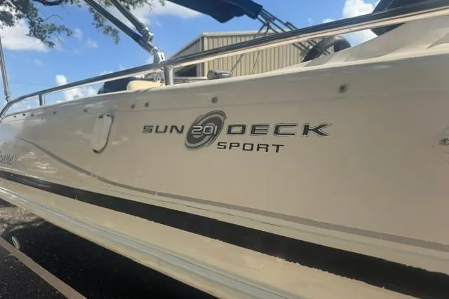 Slide: The Image of 1999 Hurricane SunDeck Sport 201 OB boat, side view with logo, outdoors. - 10