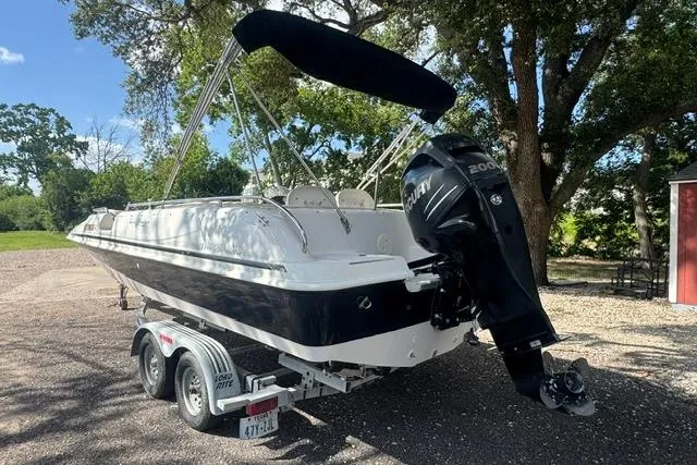 Slide: The Image of 1999 Hurricane SunDeck Sport 201 OB boat on trailer, featuring a powerful outboard motor. - 3