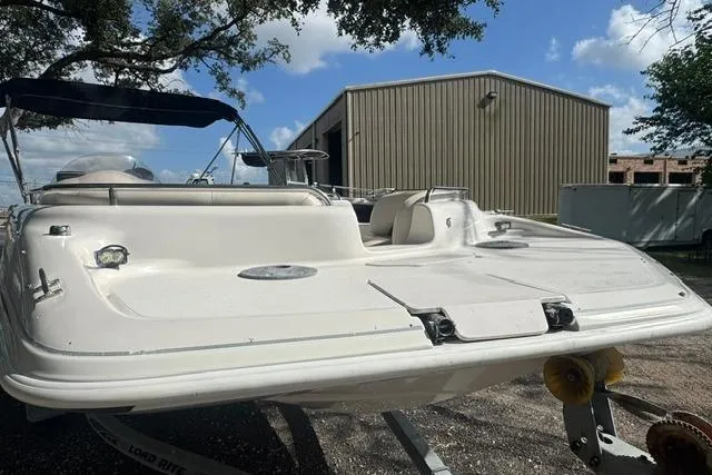 Slide: The Image of 1999 Hurricane SunDeck Sport 201 OB boat on trailer, parked near a metal building. - 8