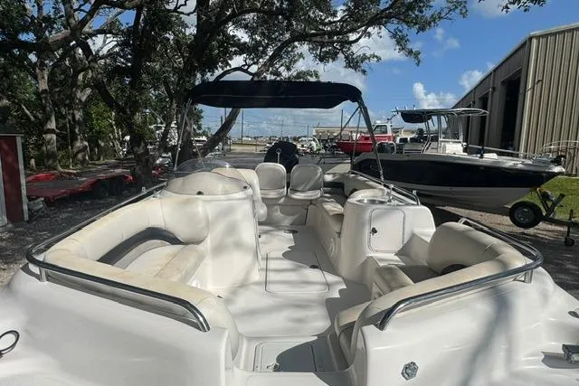 Slide: The Image of 1999 Hurricane SunDeck Sport 201 OB boat with spacious seating, docked outdoors under a clear sky. - 9