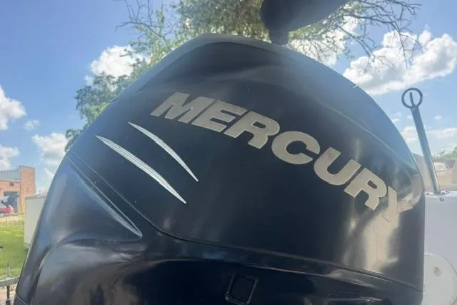Slide: The Image of Mercury outboard motor on 1999 Hurricane SunDeck Sport 201 OB boat under blue sky. - 13