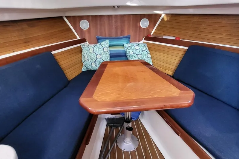 Slide: The Image of Interior of 2006 Back Cove 29 boat with wooden table and blue seating. - 20
