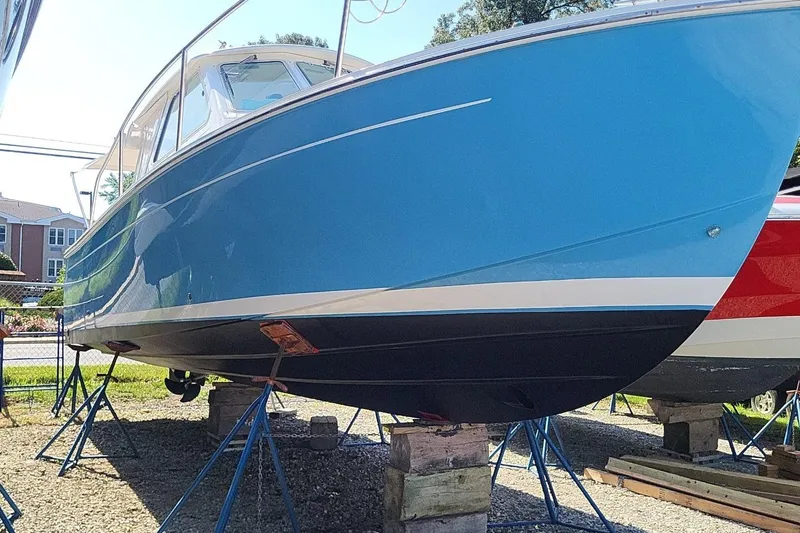 Slide: The Image of 2006 Back Cove 29 boat with blue hull on stands, displayed outdoors. - 1