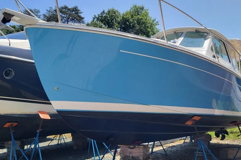 The Image of 2006 Back Cove 29 boat with blue hull on stands, outdoors. - 0