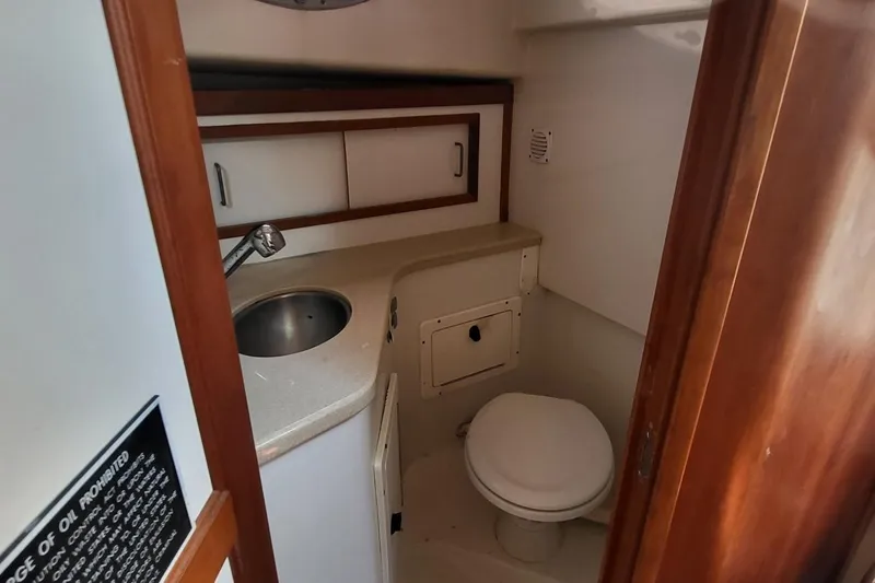 Slide: The Image of 2006 Back Cove 29 boat bathroom with sink, toilet, and storage cabinets. - 18