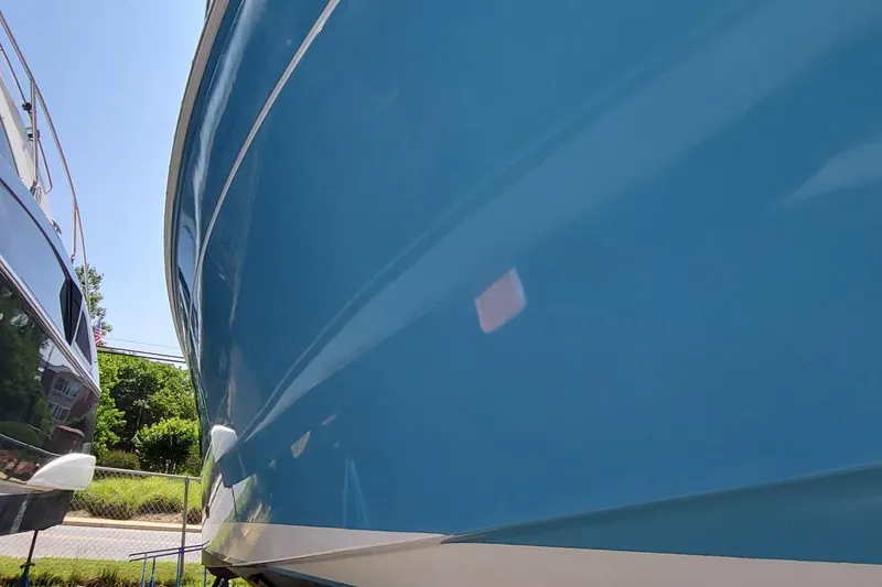 Slide: The Image of 2006 Back Cove 29 boat hull in vibrant blue, docked outdoors. - 4