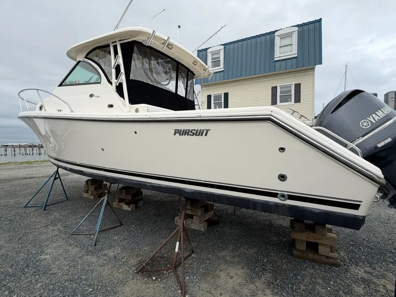 Slide: The Image of A 2009 Pursuit OS 3450 boat is on a stand on land. - 2