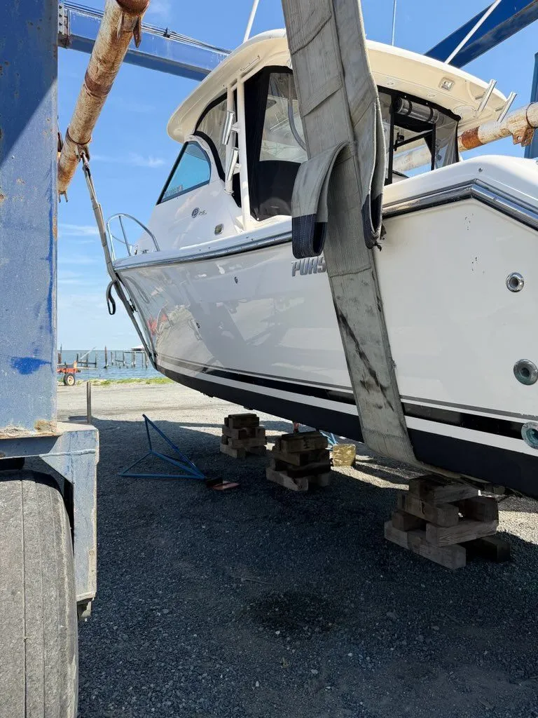 Slide: The Image of A 2009 Pursuit OS 3450 boat being lifted by a crane. - 7