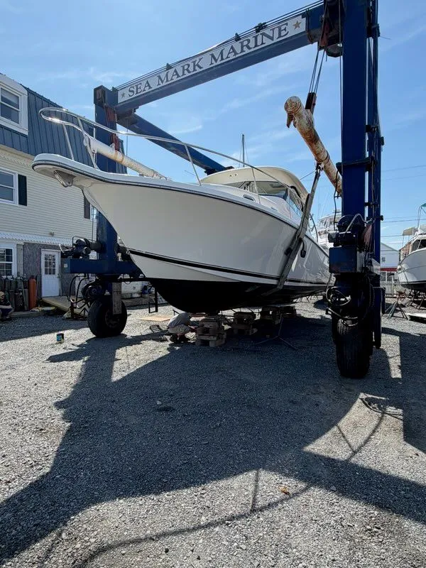 Slide: The Image of A 2009 Pursuit OS 3450 boat is being lifted in a boatyard. - 8
