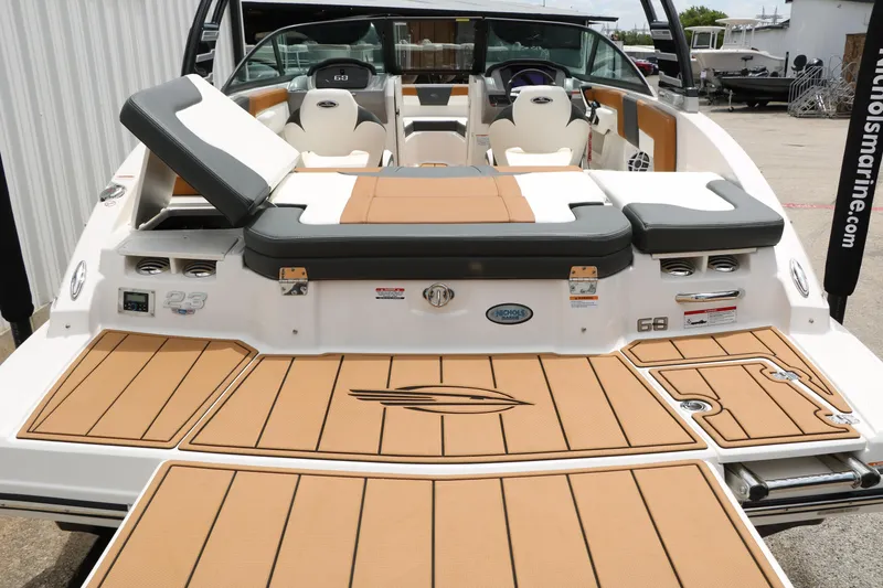 Slide: The Image of 2025 Chaparral 23 SSi boat with tan deck and seating, docked at marina. - 19