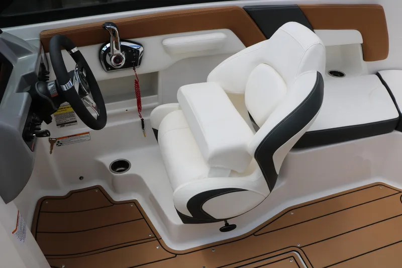 Slide: The Image of 2025 Chaparral 23 SSi boat interior with white captain's seat and modern steering controls. - 31