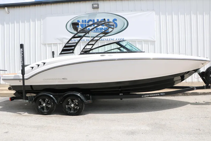 Slide: The Image of 2025 Chaparral 23 SSi boat on trailer, displayed outside a marine dealership. - 2