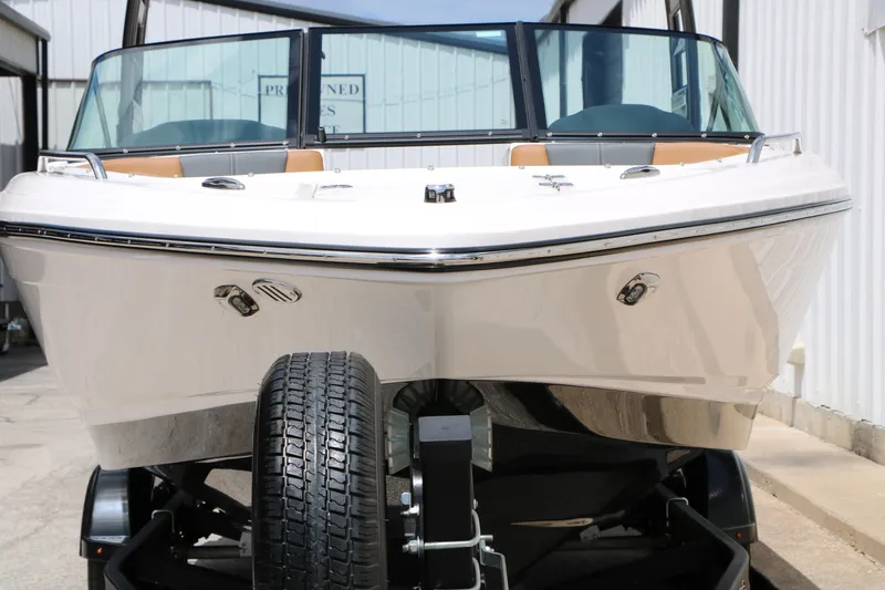 Slide: The Image of 2025 Chaparral 23 SSi boat on trailer, front view, in a marina setting. - 6