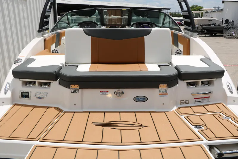 Slide: The Image of 2025 Chaparral 23 SSi boat with tan and gray seating, docked outdoors. - 20