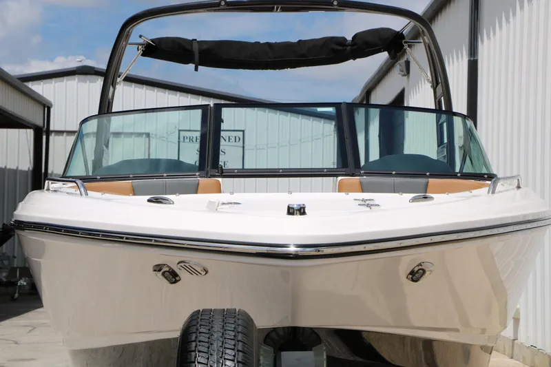 Slide: The Image of 2025 Chaparral 23 SSi boat with sleek design, docked outdoors. - 7