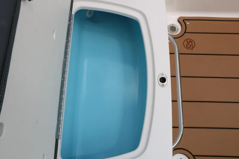 Slide: The Image of 2025 Chaparral 23 SSi boat interior with open storage compartment and teak-style flooring. - 26