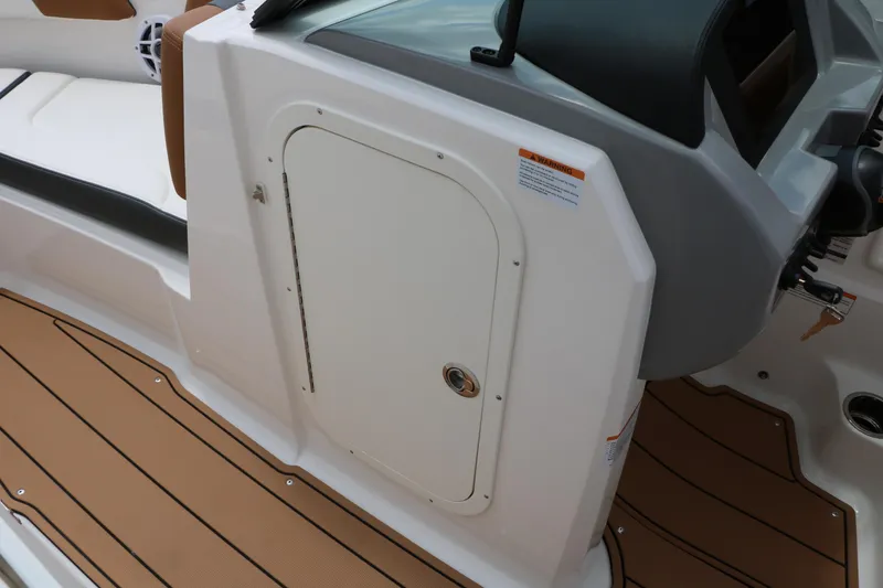 Slide: The Image of 2025 Chaparral 23 SSi boat interior with brown flooring and white seating. - 35