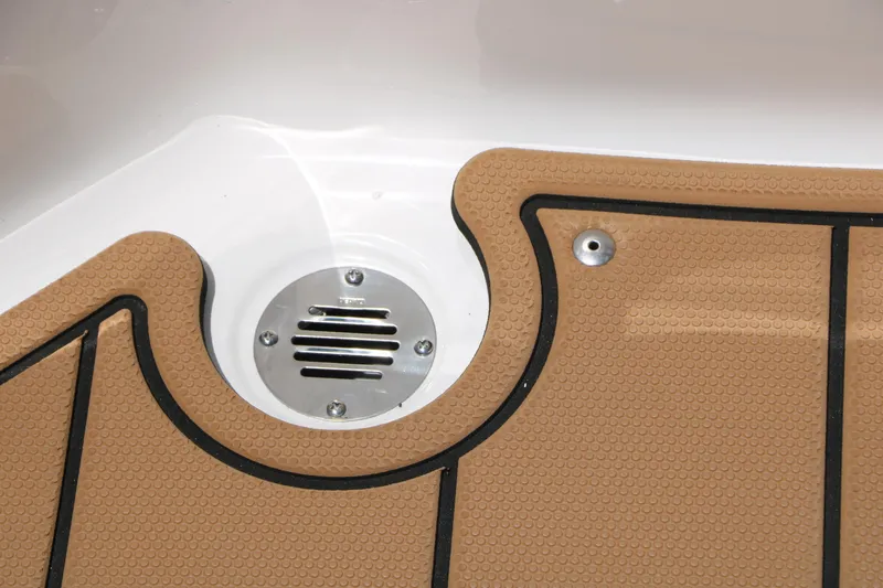 Slide: The Image of 2025 Chaparral 23 SSi boat deck with tan non-slip surface and metal drain. - 47